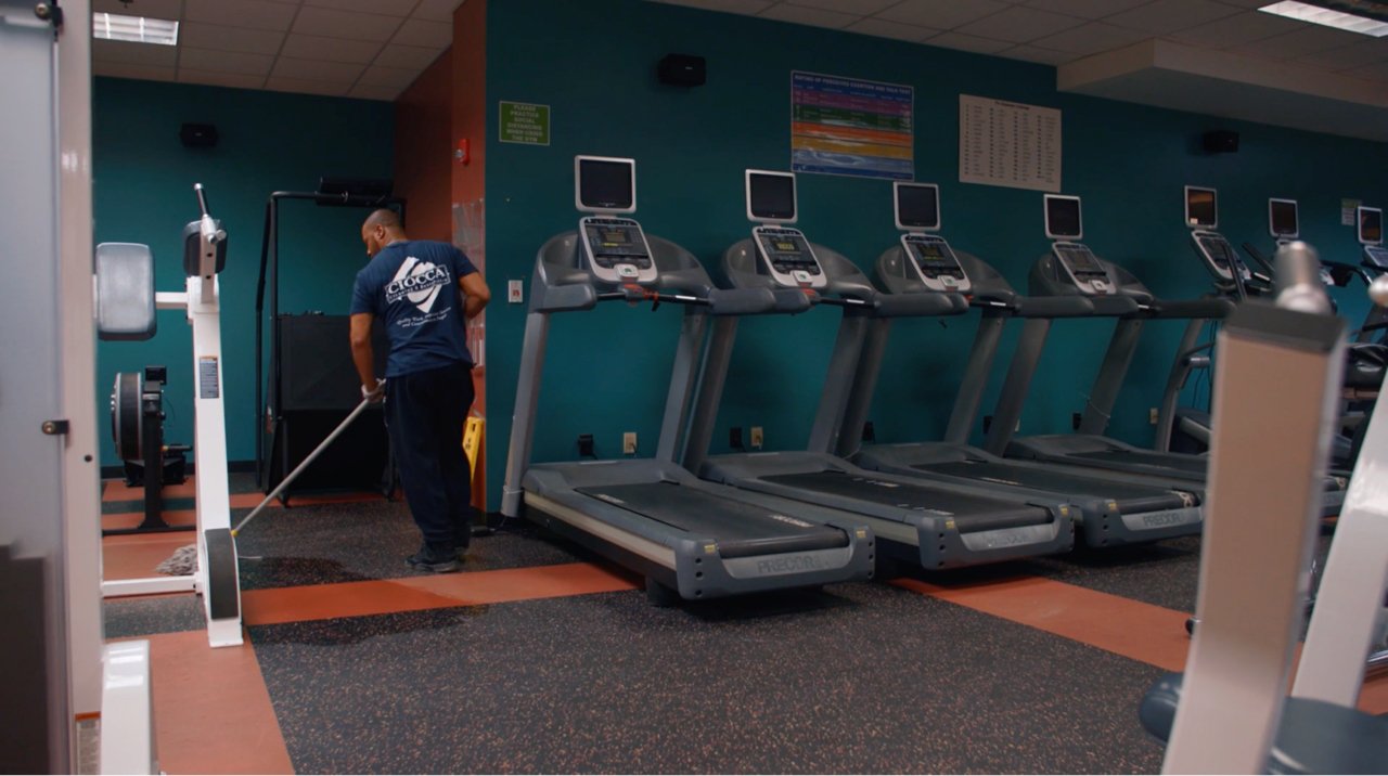 Ciocca employee moping floors in office gym with treadmills Ciocca employee moping floors in office gym with treadmills