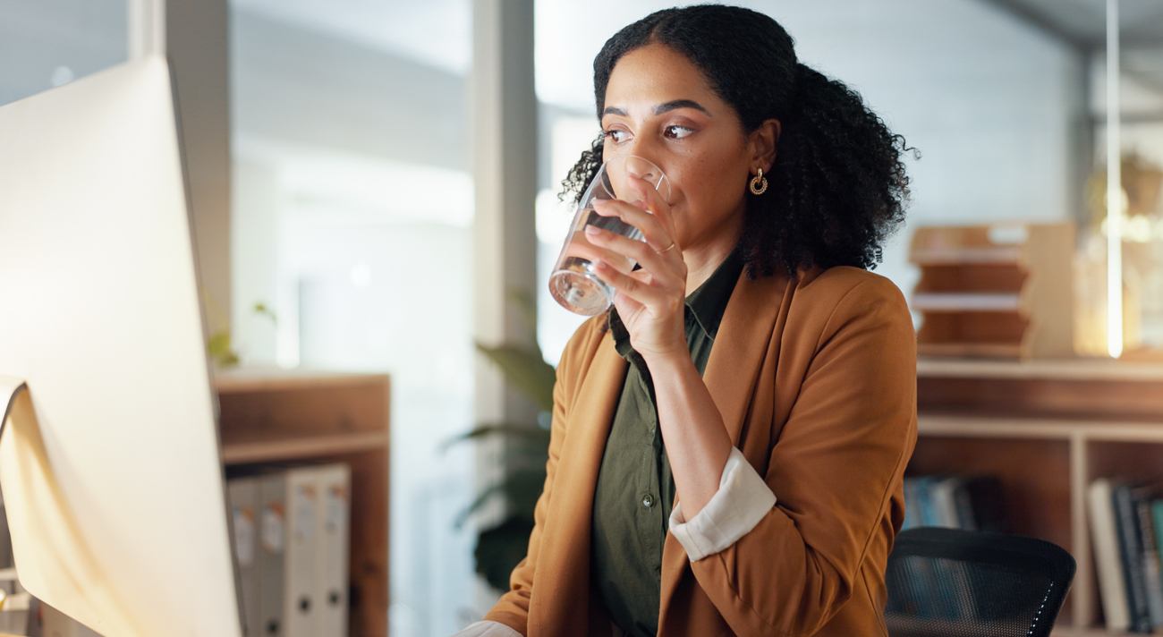 Women Drinking a Glass of Water at Work Women Drinking a Glass of Water at Work