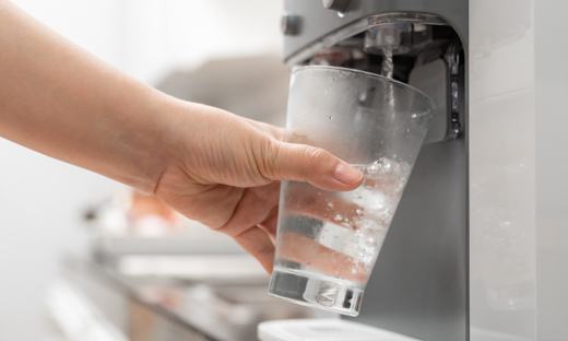 Woman filling flass of water from bottleless water system