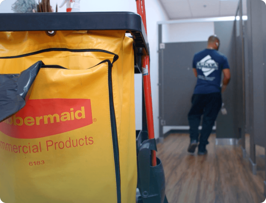 Ciocca employee cleaning stalls with cleaning cart supplies outside.