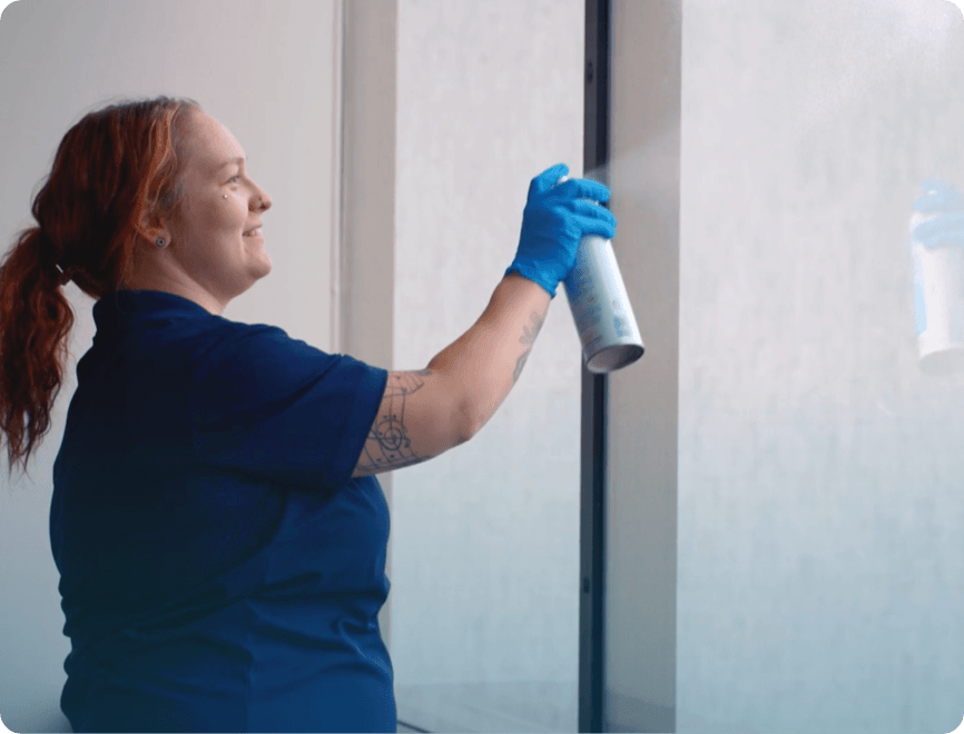 Ciocca employee spraying and cleaning window.