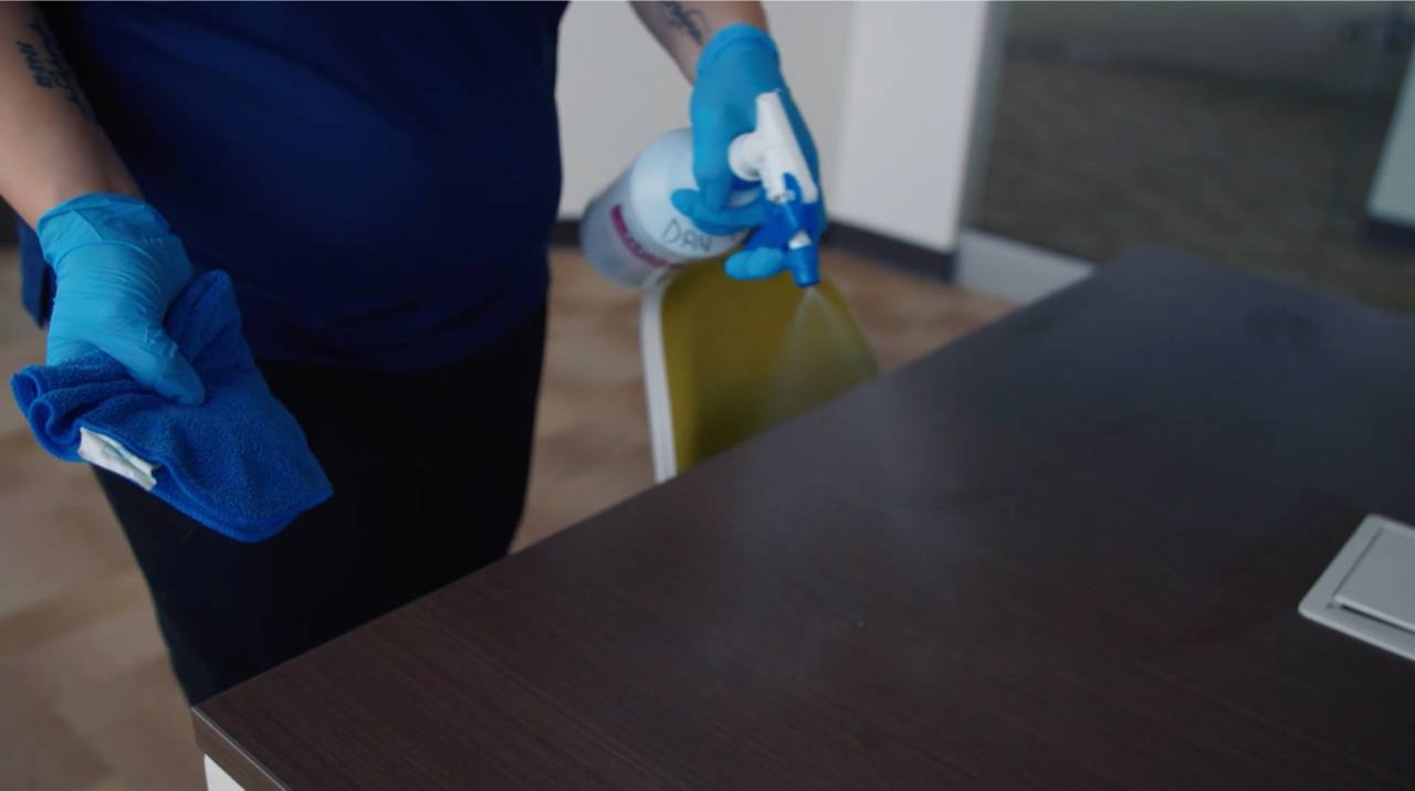 Ciocca employee disinfecting office table surface Ciocca employee disinfecting office table surface